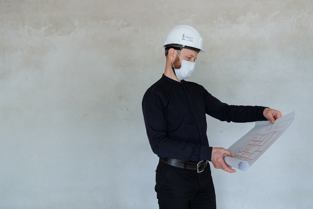a home inspector in a mask and hard hat